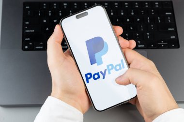 New York, ABD - 6 Nisan 2024: Popüler Paypal mobil uygulaması bilgisayarın klavye arka planında akıllı telefon ekranında