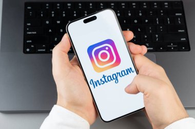New York, ABD - 6 Nisan 2024: Popüler Instagram mobil uygulaması akıllı telefon ekranında dizüstü bilgisayarın klavye arka planında