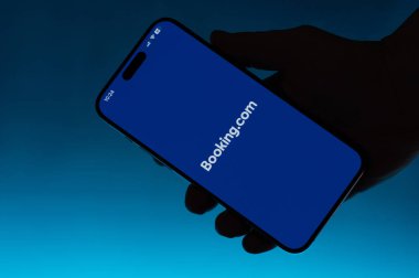 New York, ABD - 6 Mayıs 2024: Akıllı telefonda açık rezervasyon uygulaması mavi gradyan arkaplan