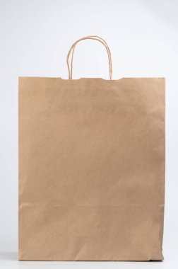 Beyaz stüdyo arka planında izole edilmiş sapları olan temiz, kahverengi bir kağıt çanta.