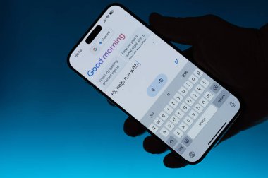 New York, ABD - 6 Mayıs 2024: Google gemini araması elinizdeki akıllı telefondan izole edilmiş mavi gradyan fon