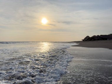 Sahilde okyanus dalgaları alacakaranlık altın renkleriyle