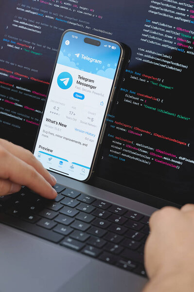 New York, USA - February 23, 2024: Code for new Telegram app in laptop screen with hands on keyboard