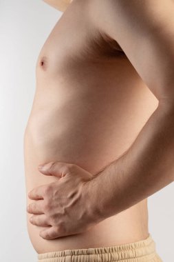 Göbeği düz gövdeli adam stüdyo arka planında izole edilmiş.