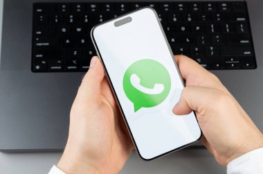 New York, ABD - 6 Nisan 2024: Popüler Whatsapp mobil uygulaması akıllı telefon ekranında dizüstü bilgisayarın klavye arka planında