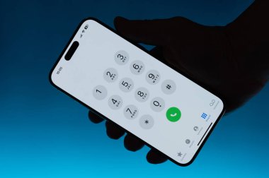 New York, ABD - 6 Mayıs 2024: Akıllı telefondaki arama numarası menüsü elde izole edilmiş mavi gradyan fon