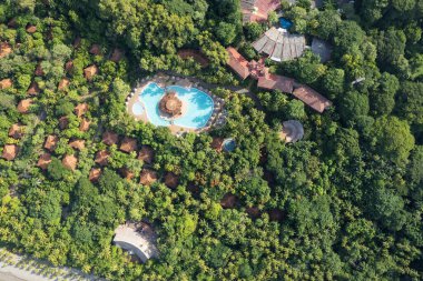 Büyük havuzu ve çatısı olan cennet tropikal tatil köyü hava aracı manzaralı.