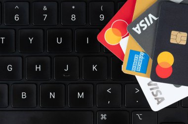 New York, ABD - 5 Temmuz 2024: Siyah dizüstü bilgisayar klavyesinin üzerinde kredi kartları ile ödeme 