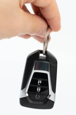 Beyaz stüdyo arka planında izole edilmiş modern araba anahtarı asılı.