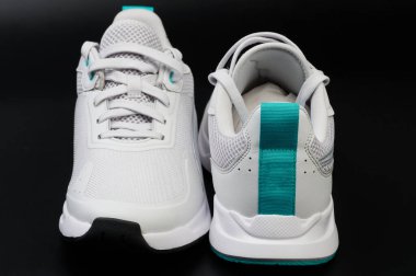 Siyah stüdyo arka planında izole edilmiş beyaz spor ayakkabılar.