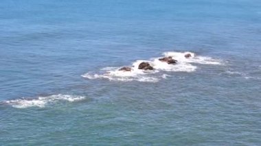 Yeşil deniz suyunda taş kaya. Hava aracı görüntüsü.