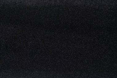 Siyah yumuşak tekstil dokusu ve küçük saç yakın görünümü.