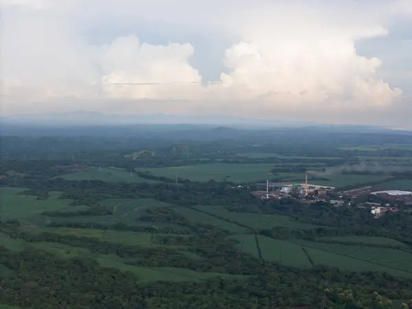 stock image Big factory with tall smokey chimney on green landscape aerial drone view