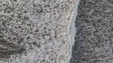 Beyaz okyanus dalgaları en üstteki dron görüntüsünün üzerinde