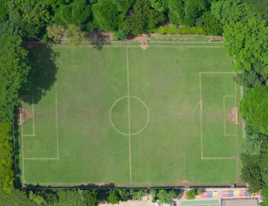 Güneşli bir günde tepede yeşil futbol sahası