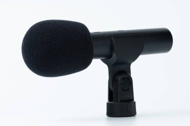 Beyaz stüdyo arka planında yalıtılmış rüzgar koruması ile siyah mikrofon çok yönlü