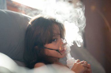 Astım maskesi ve buharı olan hasta kız dışarı çıkıyor.