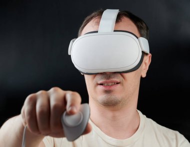 Mutlu adam siyah stüdyo arka planında izole edilmiş VR oyunları oynuyor