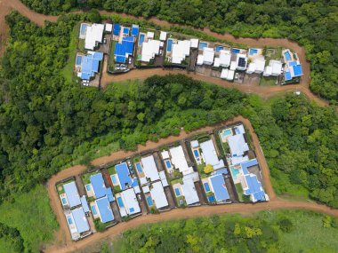 Doğa arka planında havuzları olan yerleşim evleri üst manzaranın üzerinde.