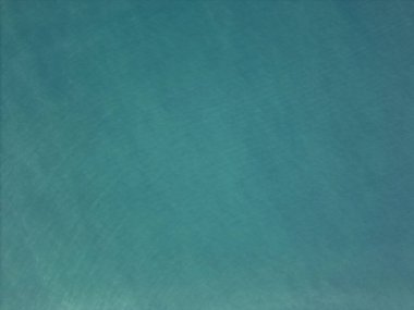 Green tropical sea water with small waves above top drone view