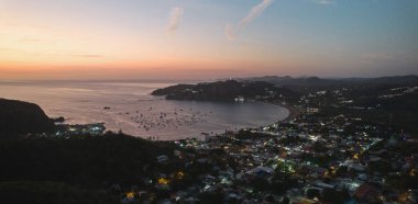 Cityscape of San Juan Del Sur at dusk time aerial drone view clipart