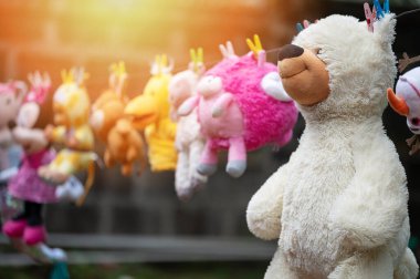 Beyaz pofuduk yumuşak oyuncak ayı güneş bahçesinde kuruyor.