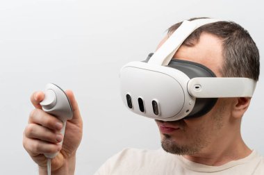 New York, ABD - 5 Kasım 2024: Meta Quest 3 vr kulaklık kullanan adam beyaz stüdyo arka planı