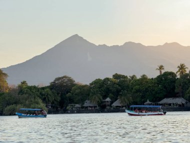 Volkanlı tropikal manzarayı görmek için turneye çıkan tekneler.