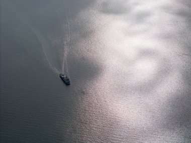 Parlak bir günde göl üzerinde hareket eden küçük bir feribot.
