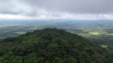 Bereketli yeşil tarlalar, gün ortasında parlak mavi gökyüzünün altında kabarık bulutlar sürükleniyor..