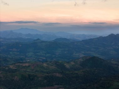 Turuncu günbatımı aydınlık hava manzaralı birçok yeşil tepe manzarası