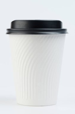 Stüdyo arka planında siyah kapaklı beyaz kağıt bardak.