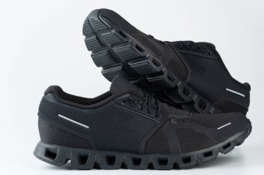 Beyaz stüdyo arka planında izole edilmiş siyah hafif spor ayakkabılar.