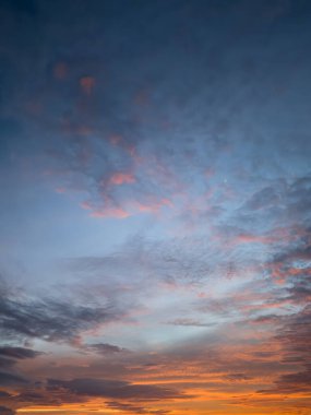 Güneşin sakin bir akşamda batışı gibi büyüleyici gökyüzü mavi, pembe ve turuncu renkler sergiliyor ve sakin bir atmosfer yaratıyor..