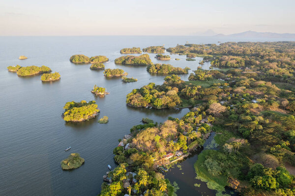 Green lake coast with small islands aerial drone view