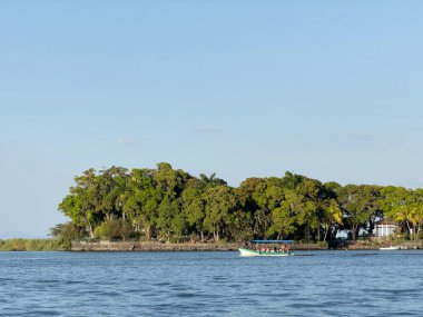 Tropikal gölde gün batımında tekne gezisi.