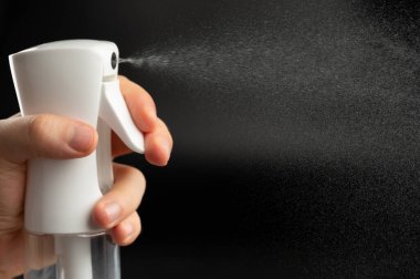 Plastik şişeden siyah arka planda su püskürtme jeti yakın görüş