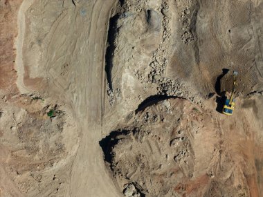 İnşaat alanındaki açık gökyüzünün altındaki araziyi yeniden şekillendirmekle meşgul ağır makineler..