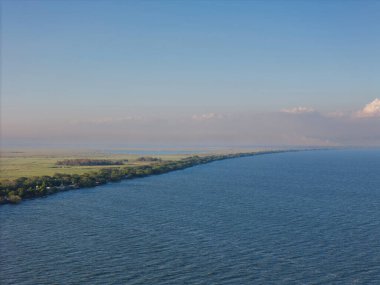 Resimli nehir manzarası, altın saat boyunca zengin yeşilliklerle çevrili huzurlu suları gösteriyor..