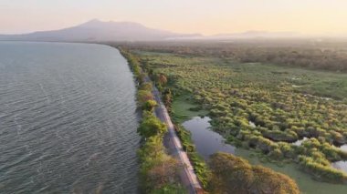 Gün batımında yemyeşil ve uzak dağlarla çevrili engin su kütlesinin yanında güzel kıyı yollarını keşfedin..