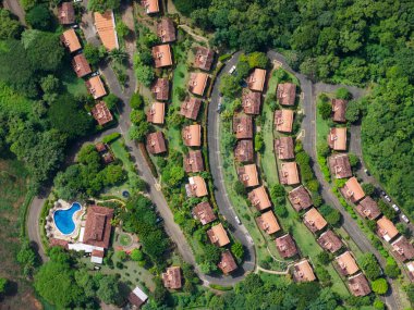 Kırmızı çatısı, caddesi ve havuzu olan tropikal bir ev.