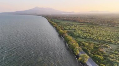 Yeşil ağaçlar ve volkanik arka plan hava aracı manzaralı göl kıyısı