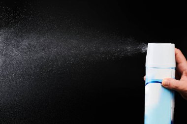 Püskürtücüden gelen hava akımı siyah stüdyo arka planında izole edildi