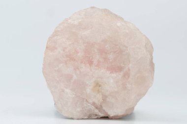 Beyaz stüdyo arka planında izole edilmiş pembe ham kristal taş.