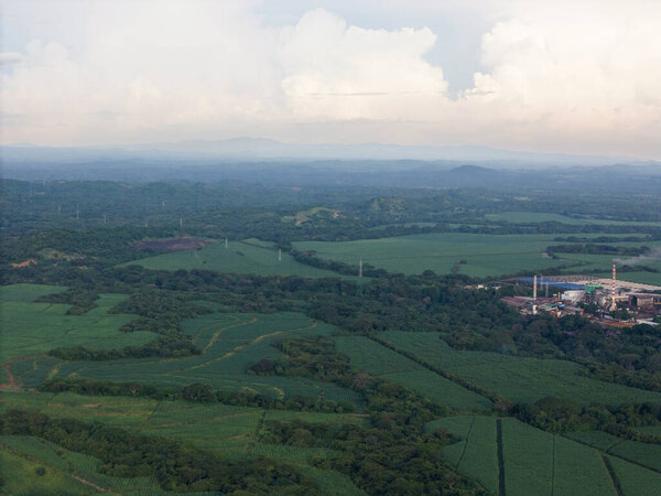 Green farmland with big factory aerial drone view