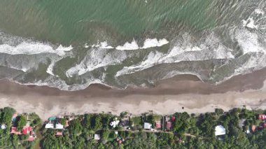Kıyıya yakın evleri olan güzel kıyı şeridini keşfedin. Gün boyunca dalgalar yavaşça kıyıya vururken..