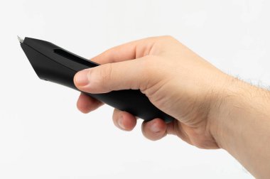 Elle siyah yazma aracını kavrıyor, pürüzsüz eğrilerini ve çağdaş tasarımını minimalist ayarlarda vurguluyor.