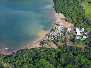 Bungalovlar ve mavi havuz tropikal plaj hava aracı manzarasının yanında.