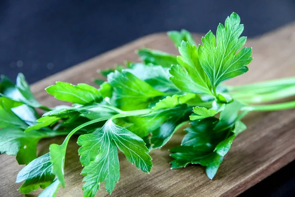 stock image Bunch of fresh parsley stem on a wooden cutting board