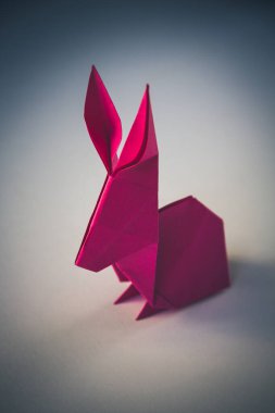 Pink paper rabbit origami isolated on a blank background.